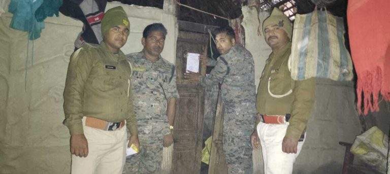 फरार वारंटी के घर चिपकाया गया इश्तेहार