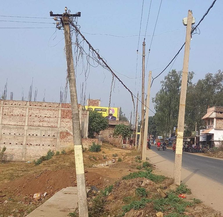 सड़क किनारे झुका बीजली का पोल