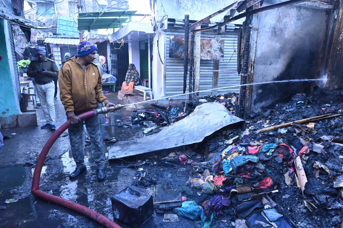 देवघर के मीना बाजार में लगी आग पर काबू पाते दमकलकर्मी