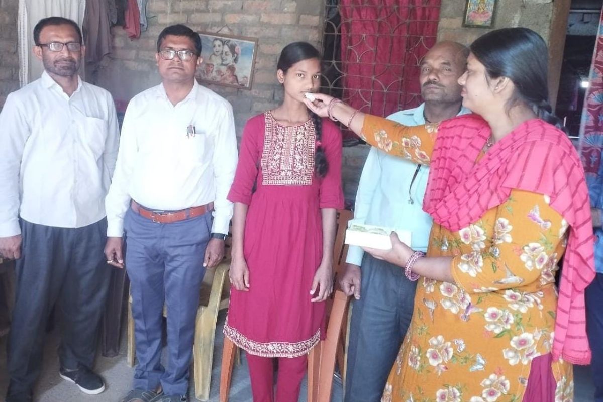 हाजीपुर, जिला टॉपर कृति को मिठाई खिलाते परिजन