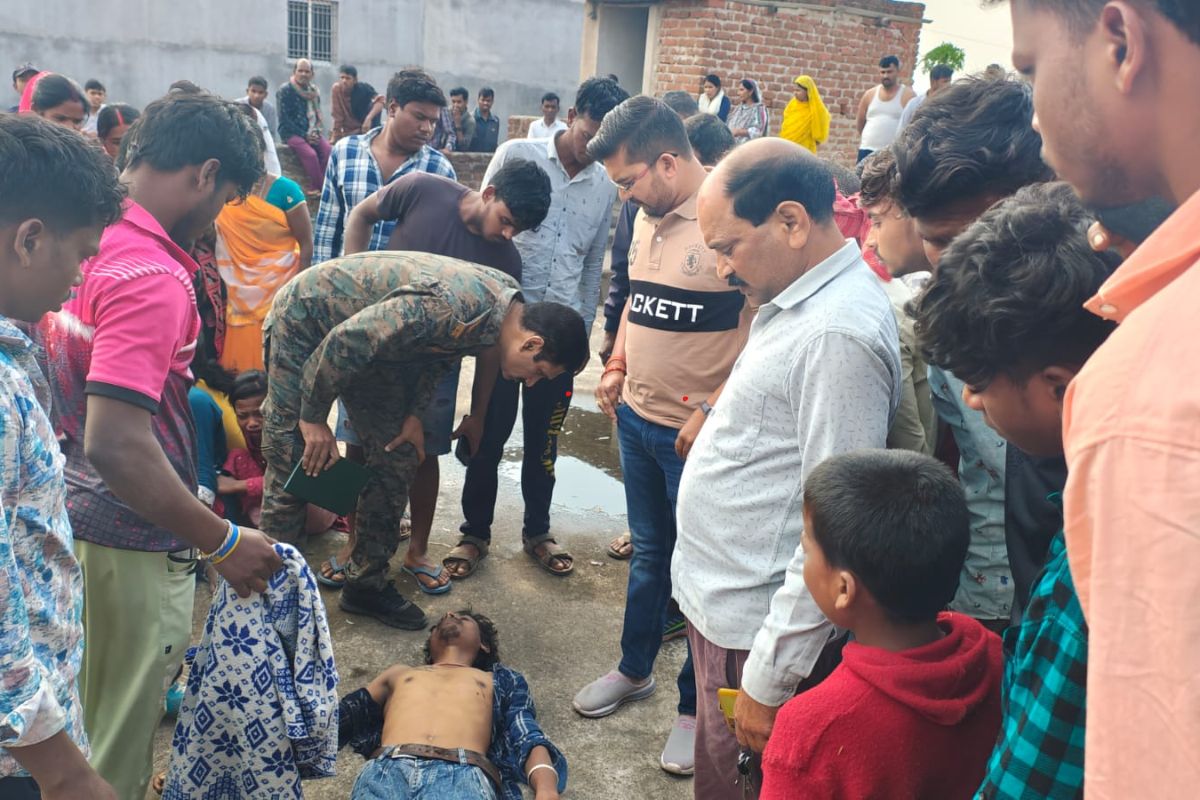 मृतक के शव को देखती पुलिस और वहां पर मौजूद भीड़