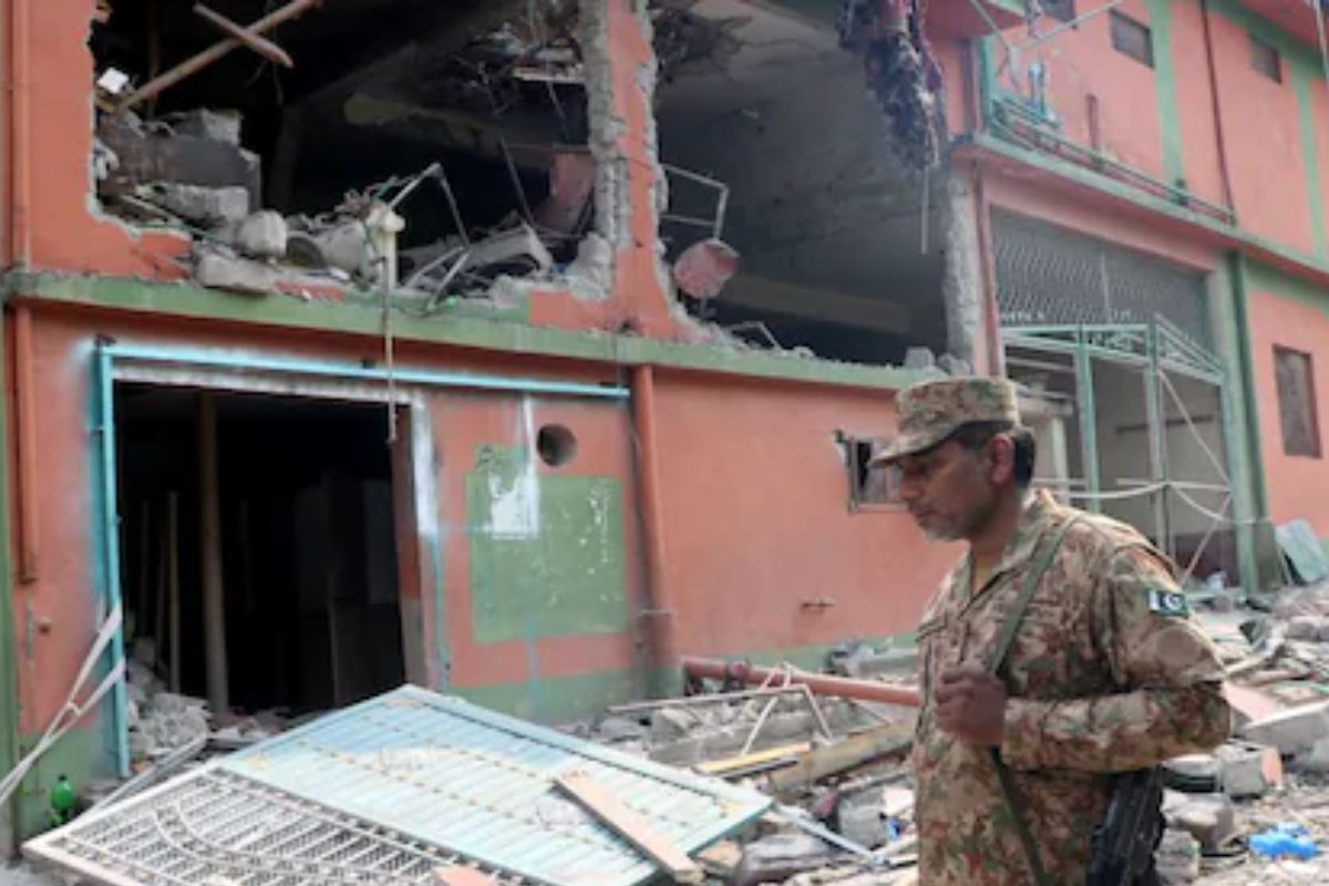 A Pakistan Army soldier stands in front of damaged building after it was hit by an Indian strike in Muzaffarabad, in PoK on May 7. Reuters