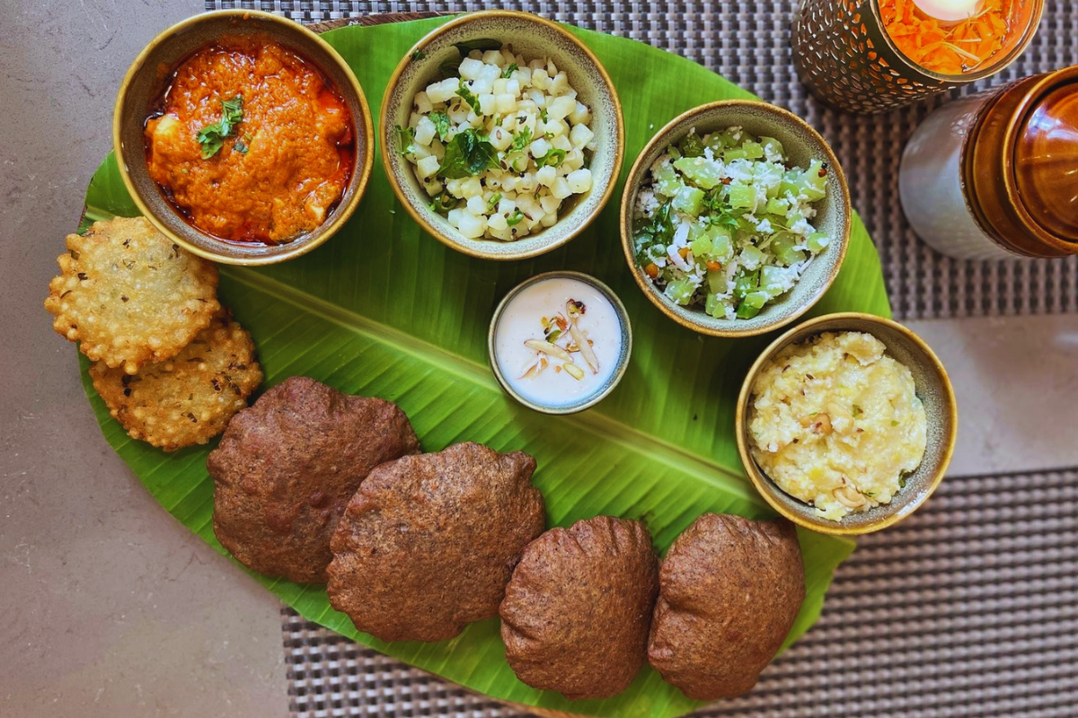 Ganesh Chaturthi Vrat Special Thali with 11 vrat-friendly dishes beautifully arranged on a traditional plate, including sabudana khichdi, aloo ki sabzi, kuttu puri, paneer curry, sweet kheer, fruits, and dry fruits, served as a festive fasting meal.