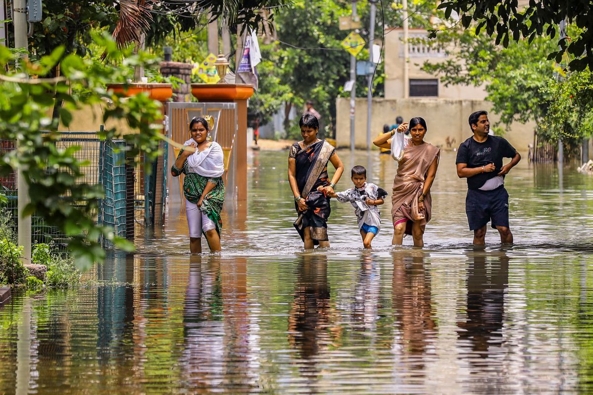 People wade through a waterlogged road