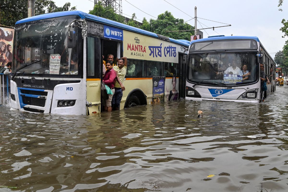 Buses move through flooded road