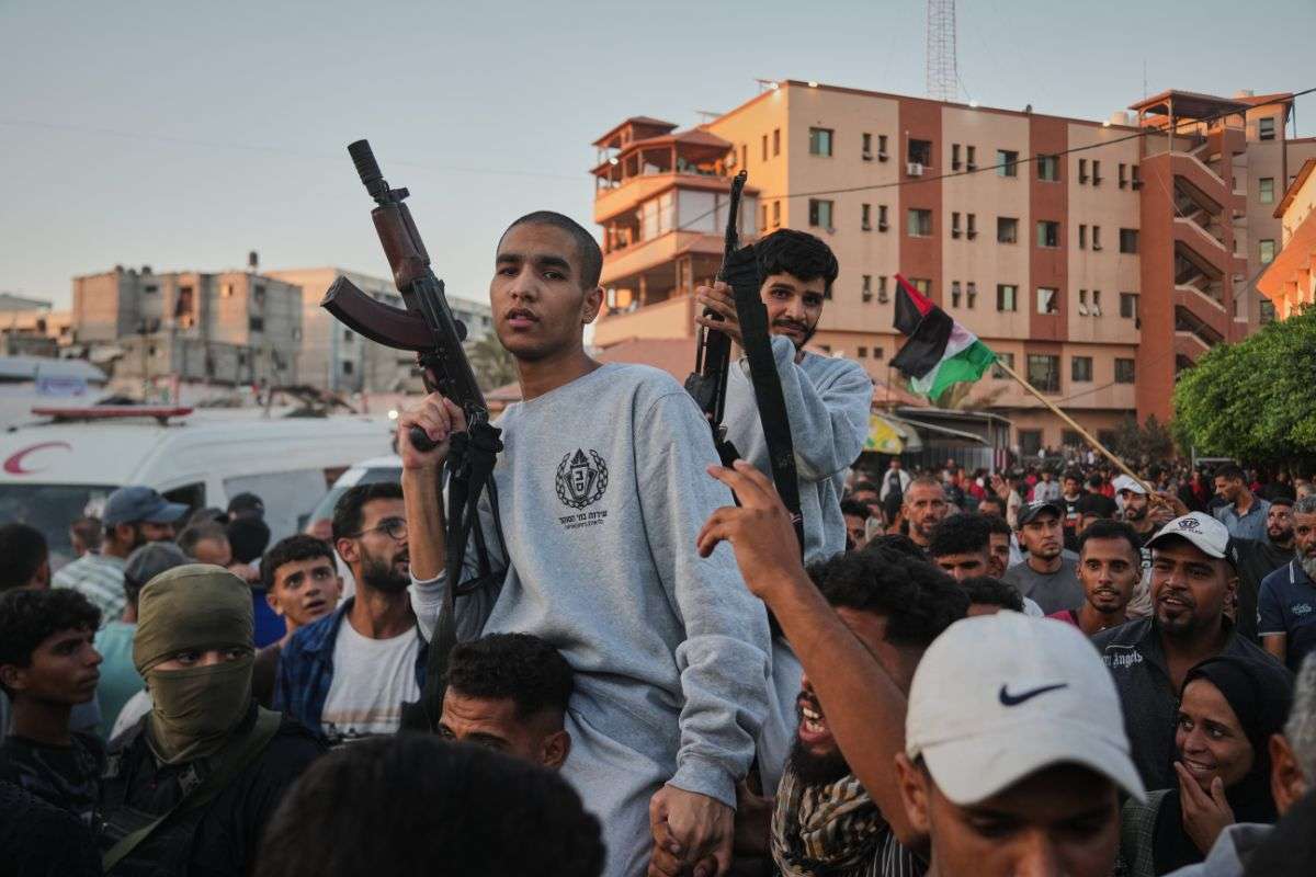 Freed Palestinian prisoners carry rifles as they arrive in the Gaza Strip.
