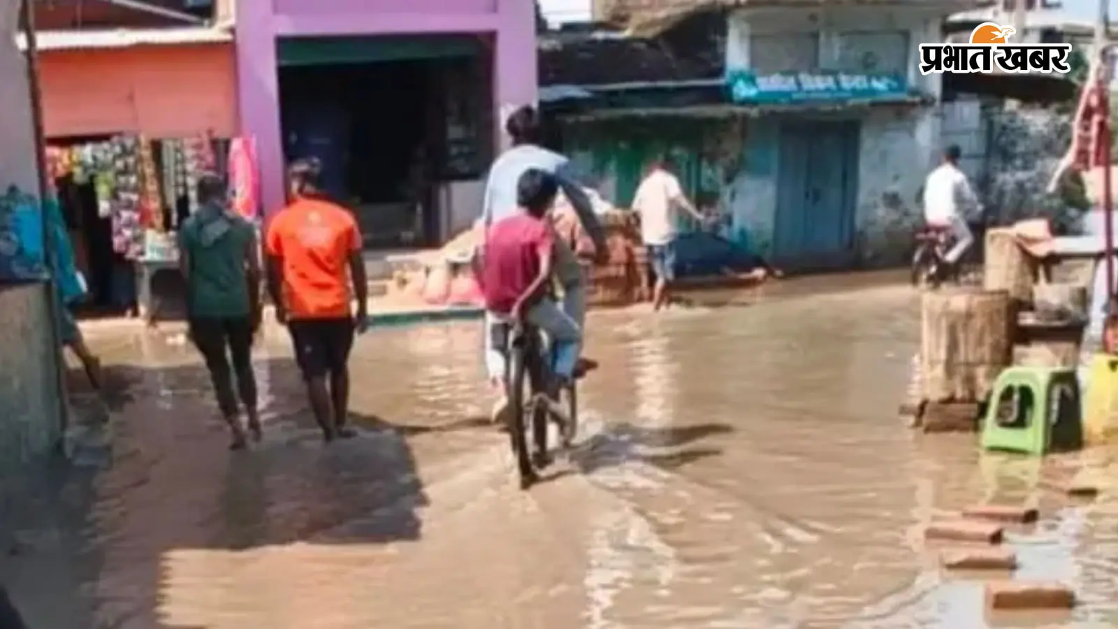 जलजमाव से गुजरते हुए स्थानीय लोग जलजमाव से गुजरते हुए स्थानीय लोग