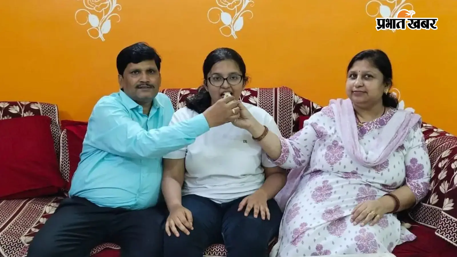 छात्रा अदिति को उनके माता-पिता मिठाई खिलाते छात्रा अदिति को उनके माता-पिता मिठाई खिलाते
