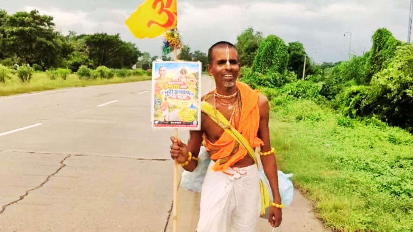 हाथ में कमंडल और भगवान श्रीकृष्ण के साथ ओम का झंडा लेकर भी चल रहे नवकुमार मल्लिक.